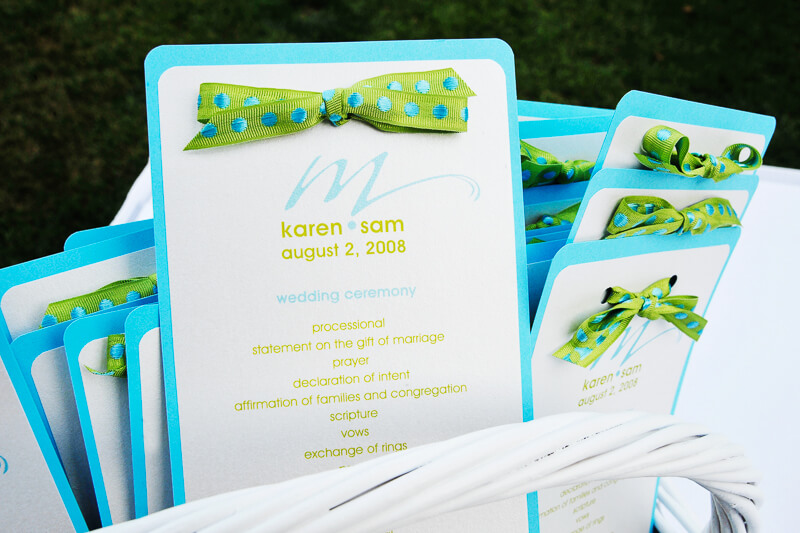 Blue and green wedding ceremony program with bow